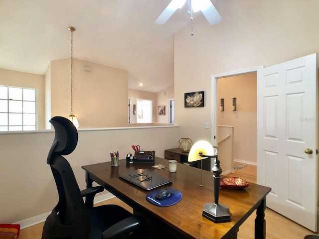 office space featuring high vaulted ceiling, light wood-style flooring, a ceiling fan, and baseboards