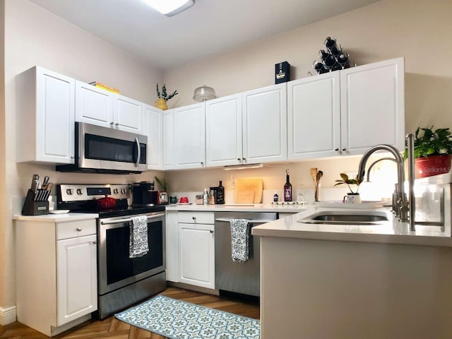 kitchen featuring white cabinetry, appliances with stainless steel finishes, light countertops, and a sink