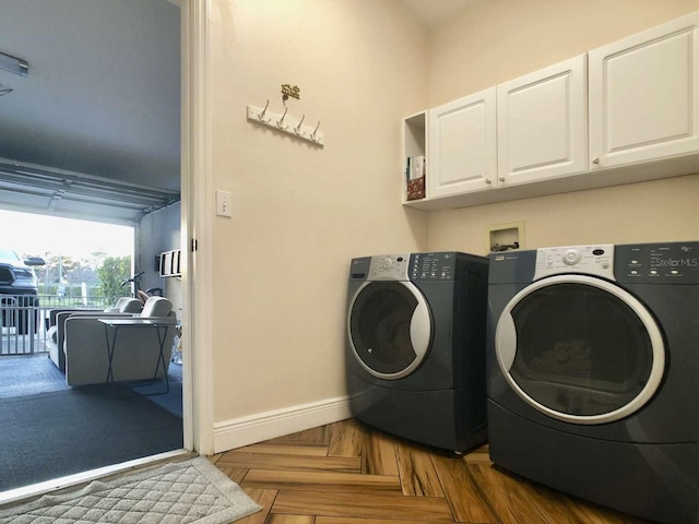 laundry room featuring washer and clothes dryer, cabinet space, and baseboards