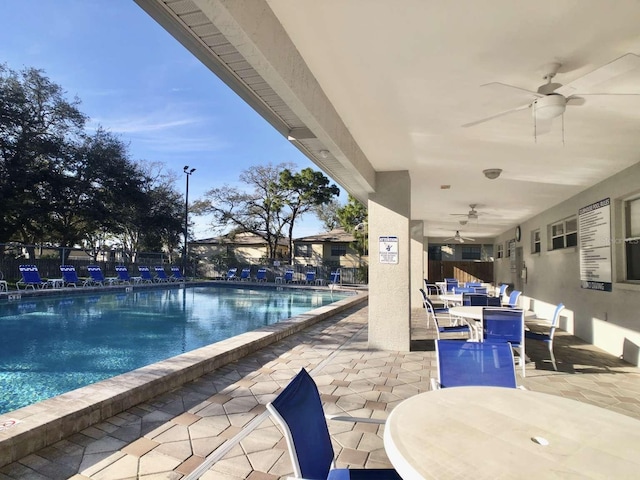 pool featuring a ceiling fan, outdoor dining space, and a patio area