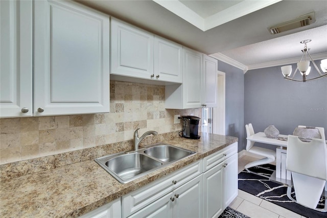 kitchen with white cabinetry, crown molding, visible vents, and a sink