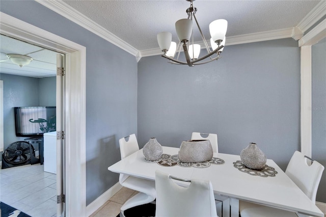 dining space featuring light tile patterned floors, a textured ceiling, crown molding, and an inviting chandelier