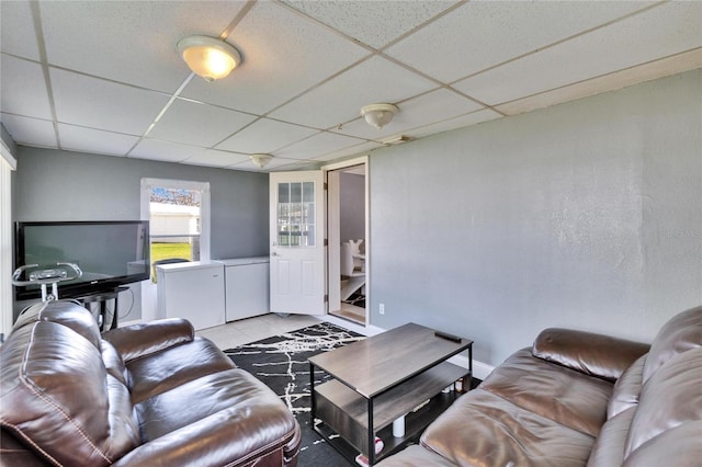 living area with a drop ceiling and light tile patterned floors