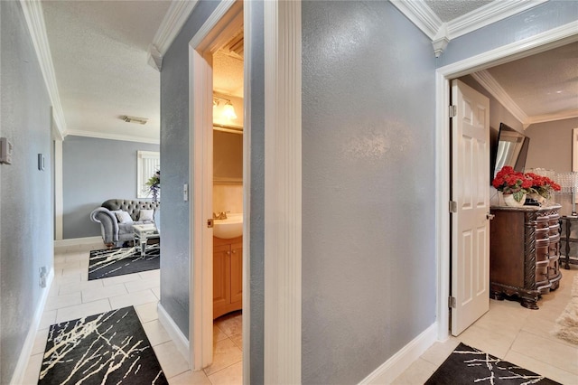 corridor with visible vents, ornamental molding, baseboards, and tile patterned floors