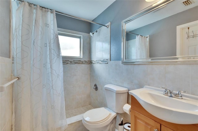 full bathroom featuring tile walls, visible vents, toilet, vanity, and tiled shower