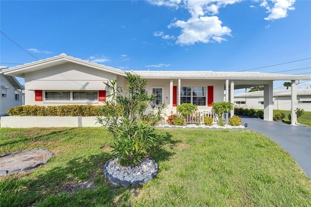 single story home featuring aphalt driveway, an attached carport, covered porch, and a front lawn