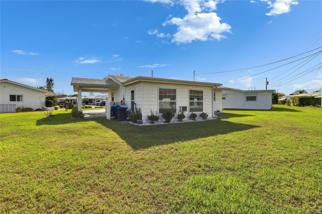 back of property with an attached carport and a yard