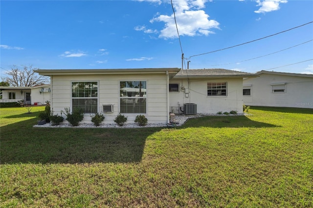 rear view of property with a yard and central AC unit