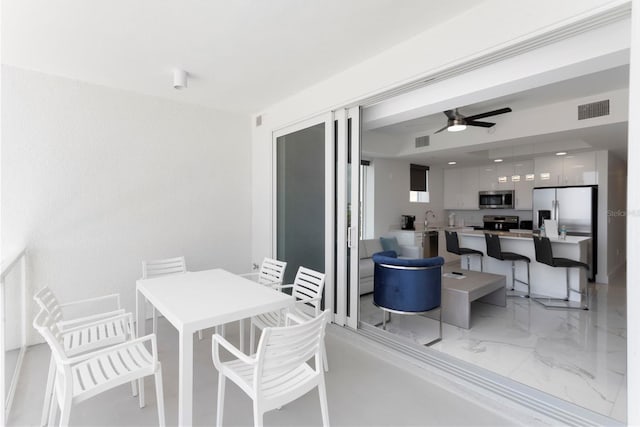 dining room with marble finish floor, ceiling fan, and visible vents