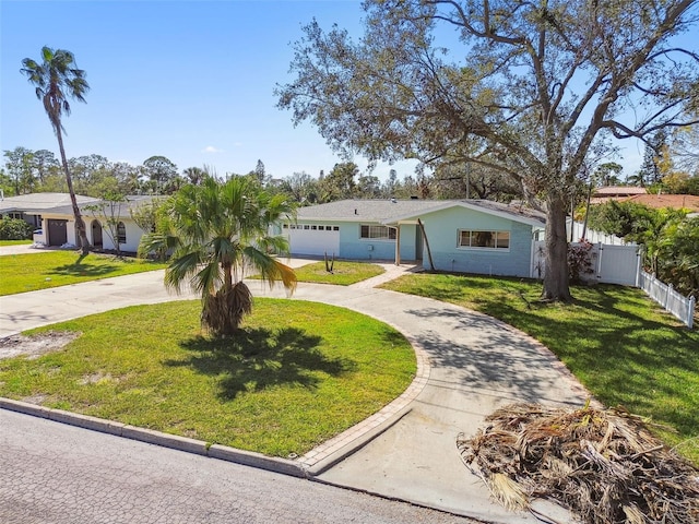 view of front of house with a front yard, curved driveway, and fence