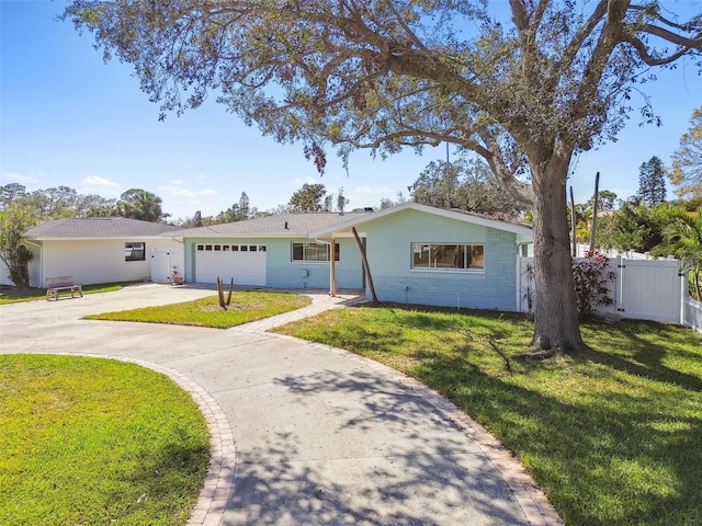 ranch-style home featuring driveway, an attached garage, fence, and a front yard