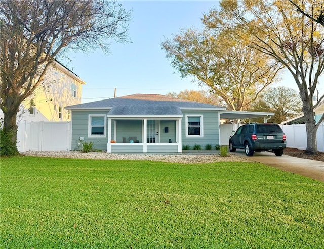 view of front of house with driveway, fence, a carport, and a front yard