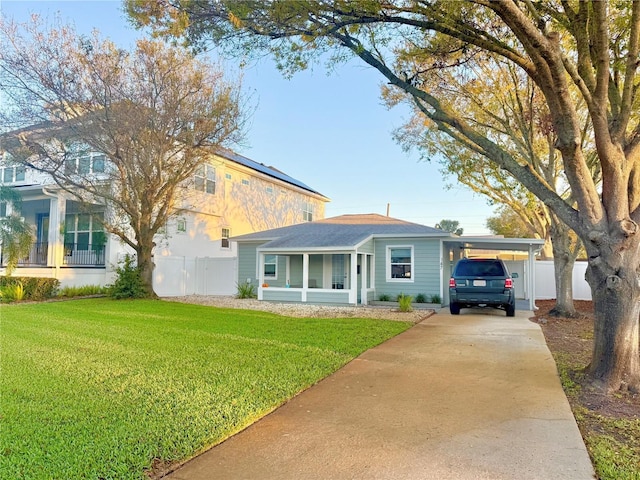 view of front facade featuring a front yard, concrete driveway, and fence