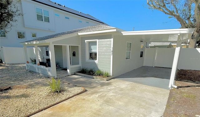 view of front facade with driveway, fence, and an attached carport