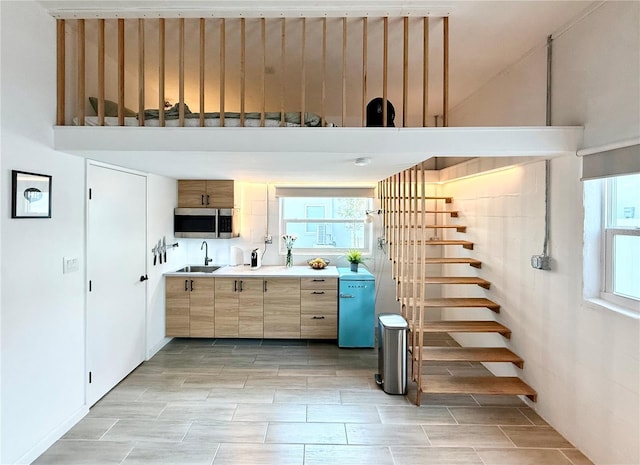 interior space with light countertops, stainless steel microwave, and a sink