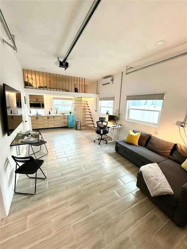 living room featuring stairs and an AC wall unit