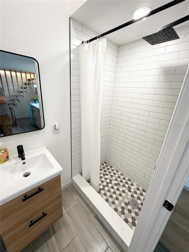 bathroom with a stall shower, vanity, and wood tiled floor