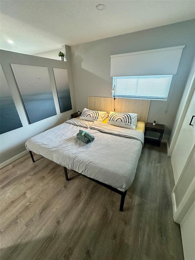 bedroom featuring a textured ceiling and wood finished floors