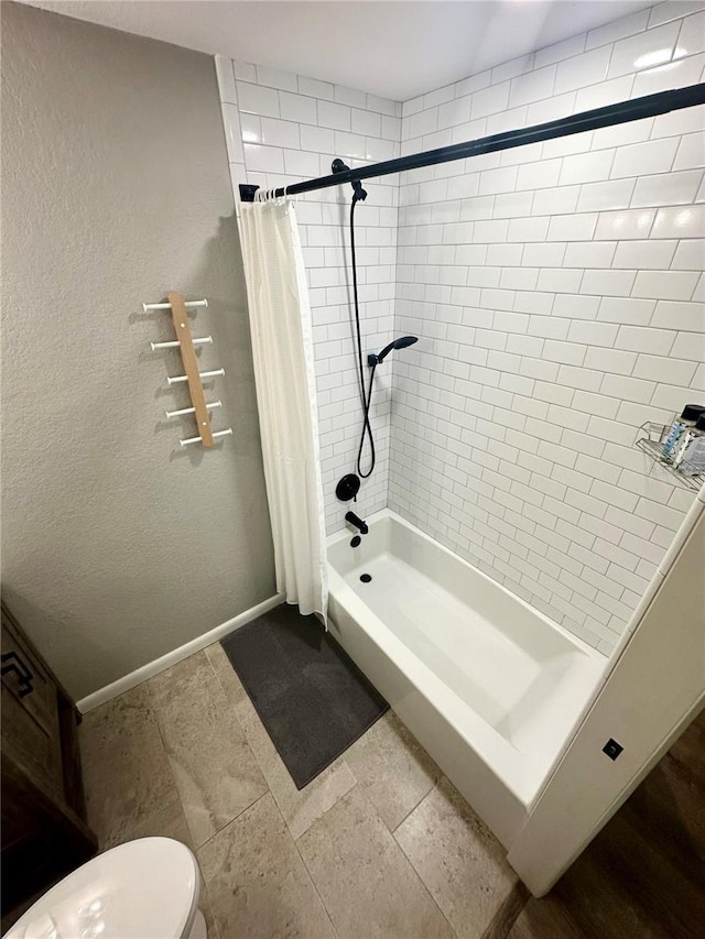 bathroom featuring a shower with curtain, baseboards, a textured wall, and toilet