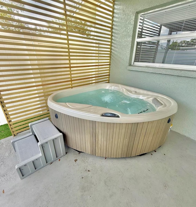 miscellaneous room featuring unfinished concrete flooring and a jacuzzi