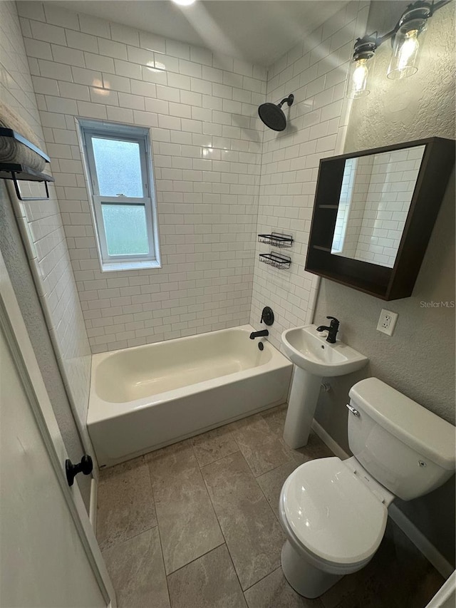 bathroom with a textured wall, shower / bathing tub combination, and toilet