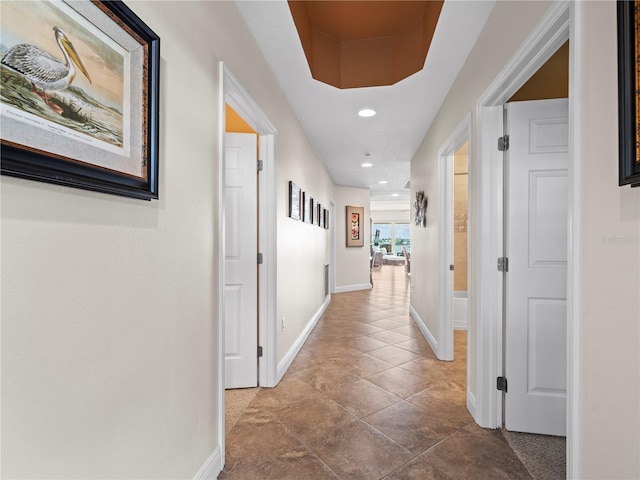 hall featuring baseboards and recessed lighting