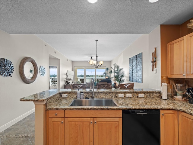 kitchen featuring black dishwasher, stone countertops, open floor plan, a sink, and a peninsula