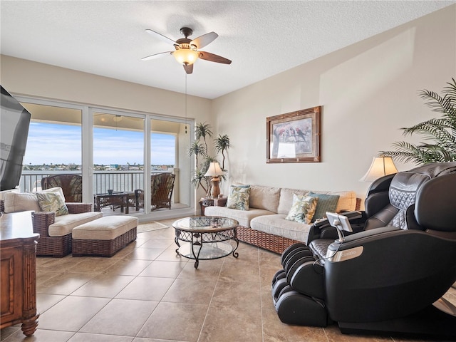 living area featuring a ceiling fan, a textured ceiling, and light tile patterned floors