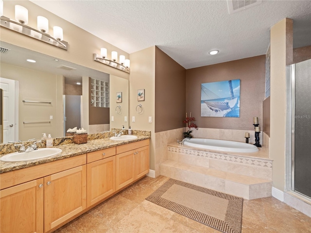 full bath featuring double vanity, visible vents, a garden tub, a shower stall, and a sink