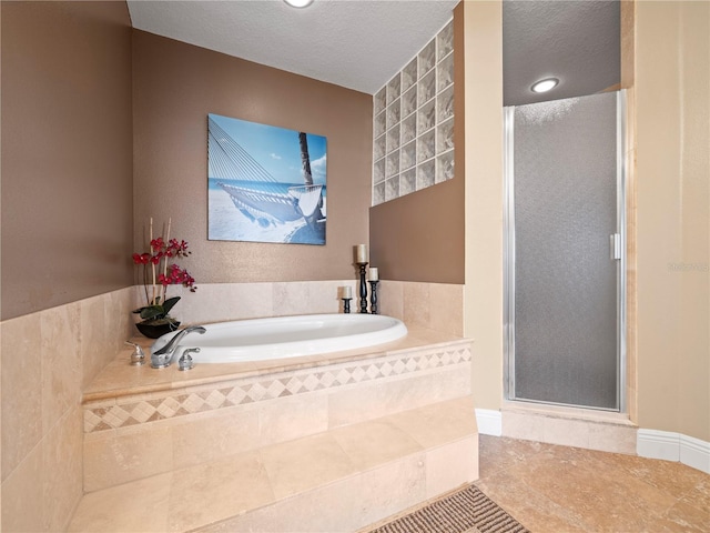 full bath featuring a stall shower, tile patterned floors, a textured ceiling, and a bath