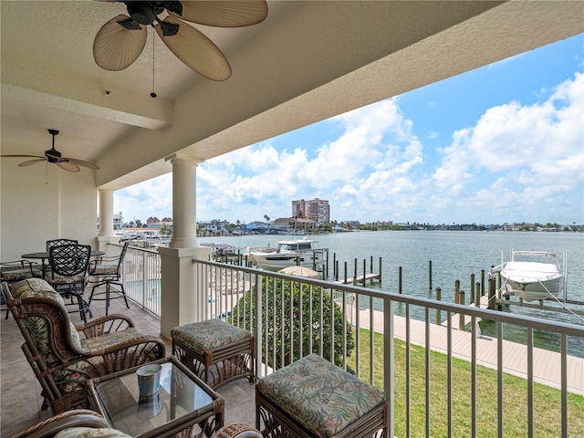 balcony featuring a ceiling fan, a water view, a boat dock, and boat lift