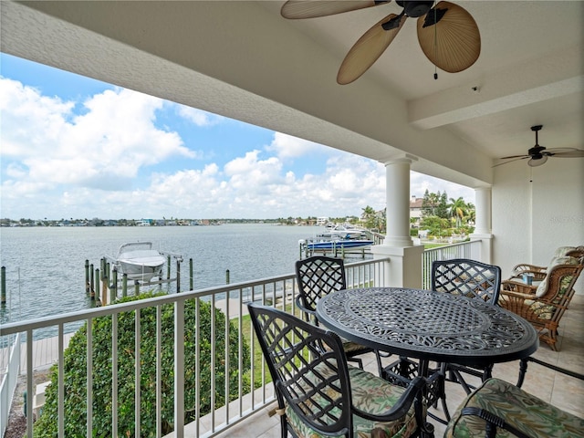 balcony featuring a ceiling fan, a dock, a water view, and boat lift