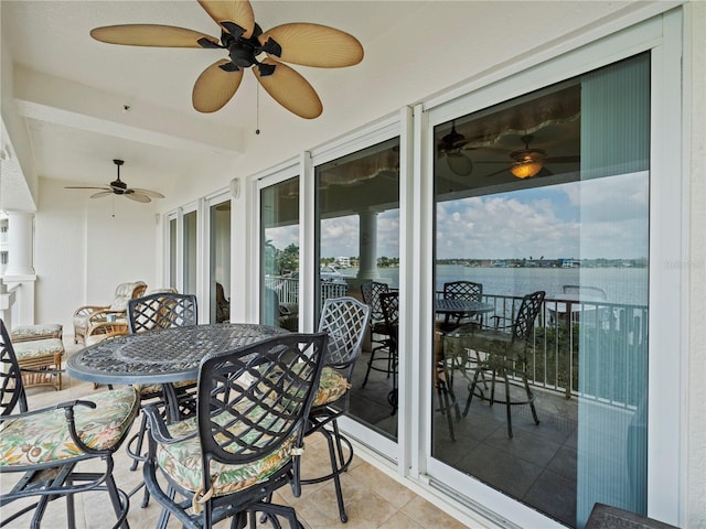 exterior space featuring outdoor dining space, a water view, and a balcony