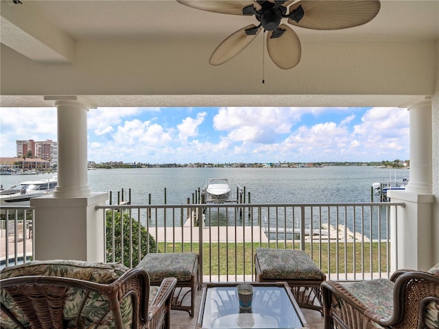 balcony featuring a dock, a water view, ceiling fan, and boat lift