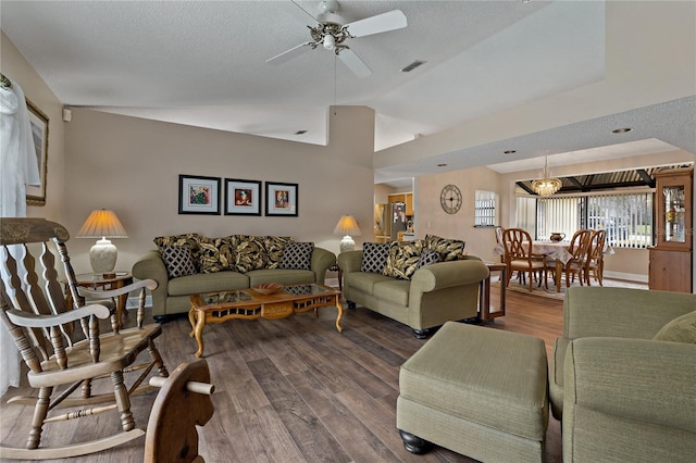 living area with ceiling fan, a textured ceiling, wood finished floors, visible vents, and vaulted ceiling