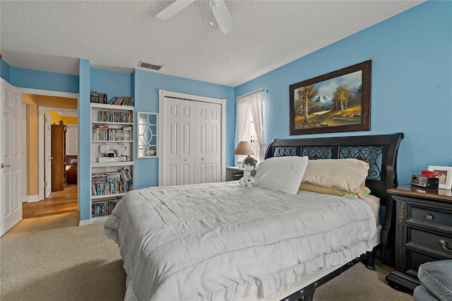 bedroom with visible vents, a ceiling fan, carpet, a textured ceiling, and a closet