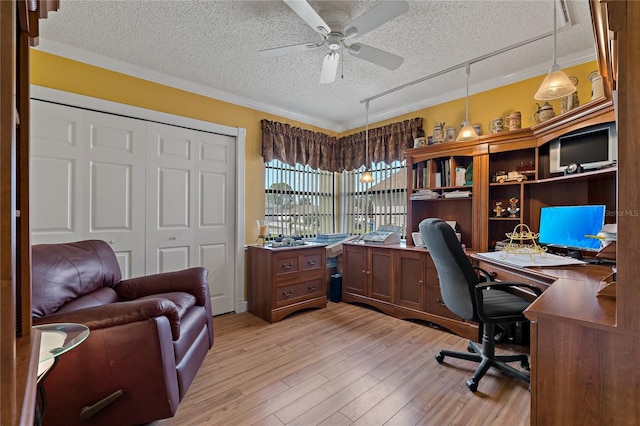 office space featuring ornamental molding, light wood-type flooring, a textured ceiling, and a ceiling fan