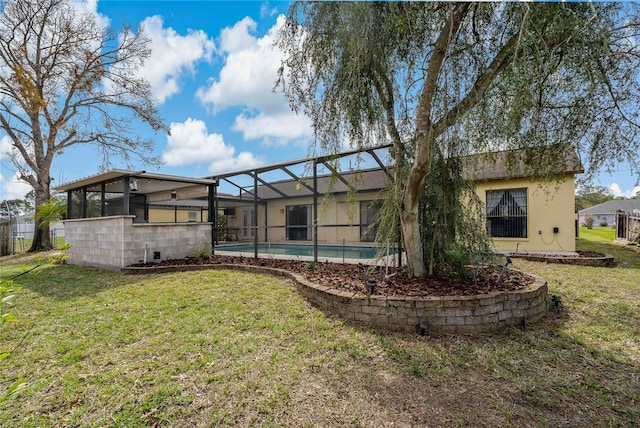 back of property with glass enclosure, a lawn, and a fenced in pool