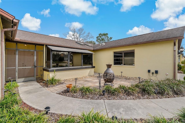 back of house featuring a patio, an outdoor fire pit, and stucco siding