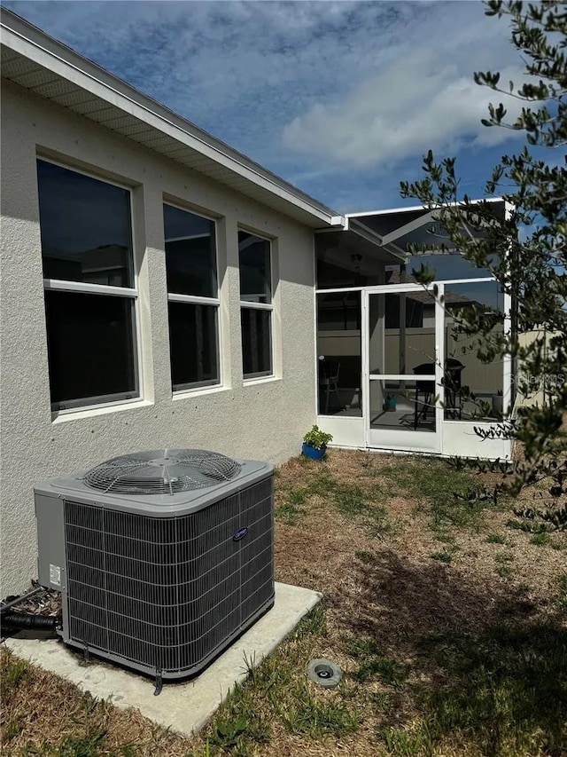 exterior details featuring stucco siding and central air condition unit