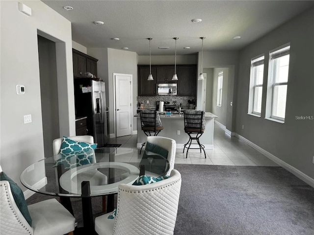 living area featuring light carpet, light tile patterned floors, and baseboards