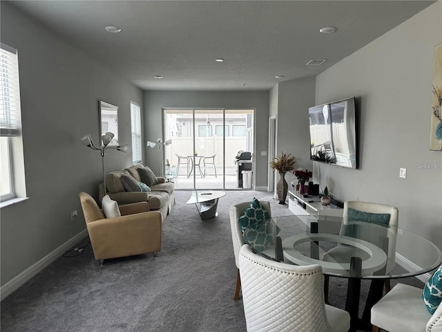 living area with carpet floors, visible vents, and baseboards