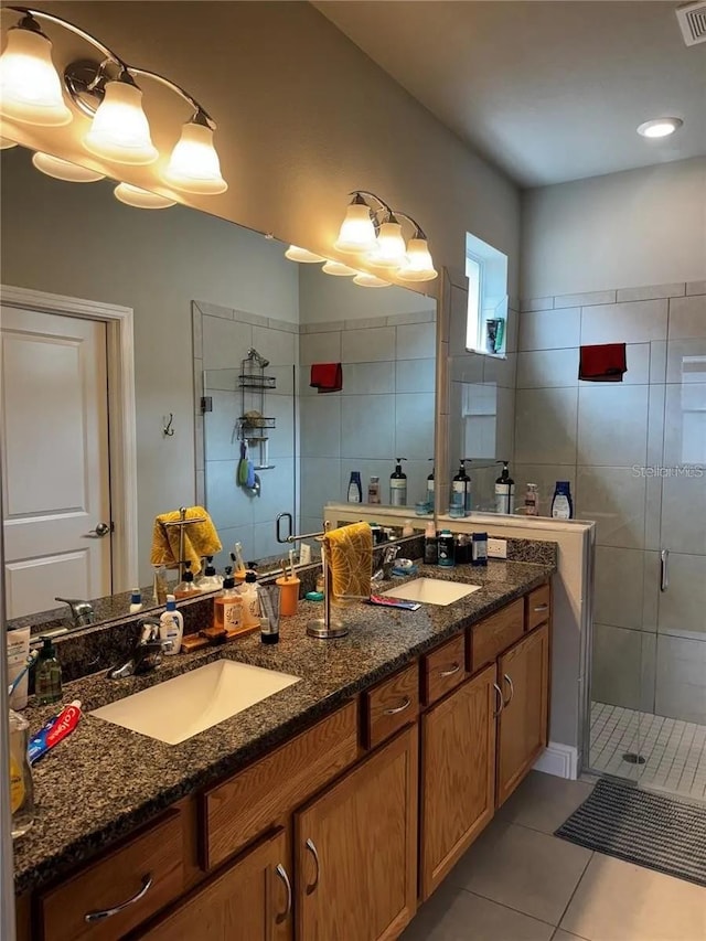 bathroom with a stall shower, tile patterned flooring, and a sink