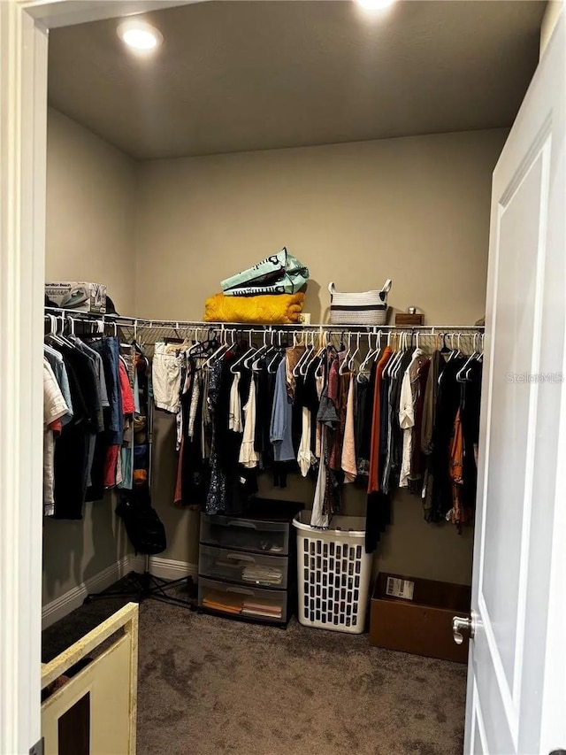 walk in closet featuring dark colored carpet