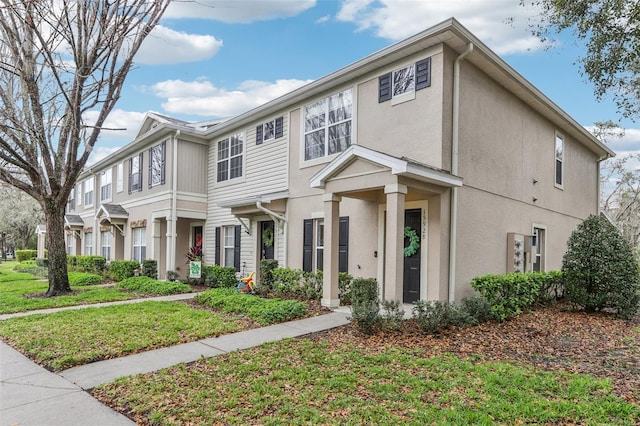 multi unit property with a front yard and stucco siding