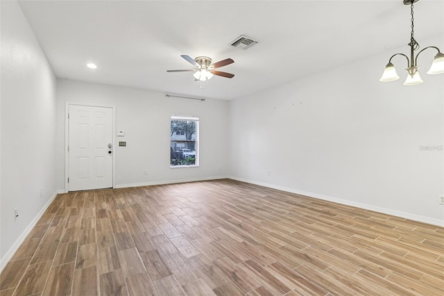 empty room with light wood finished floors, baseboards, visible vents, ceiling fan with notable chandelier, and recessed lighting