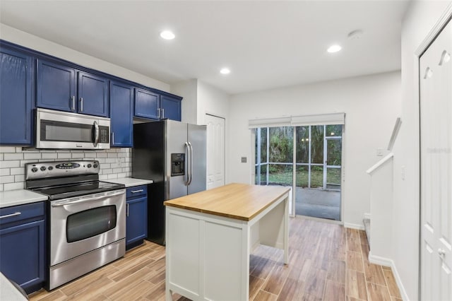 kitchen featuring stainless steel appliances, wooden counters, backsplash, wood tiled floor, and blue cabinets