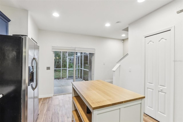 kitchen with white cabinets, light wood-style flooring, a kitchen island, stainless steel refrigerator with ice dispenser, and recessed lighting