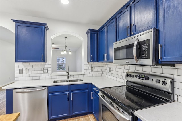 kitchen featuring light countertops, appliances with stainless steel finishes, blue cabinetry, and a sink