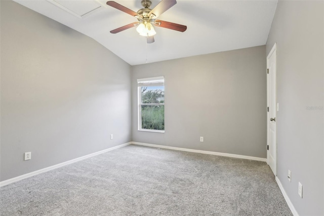 carpeted empty room with vaulted ceiling, ceiling fan, and baseboards